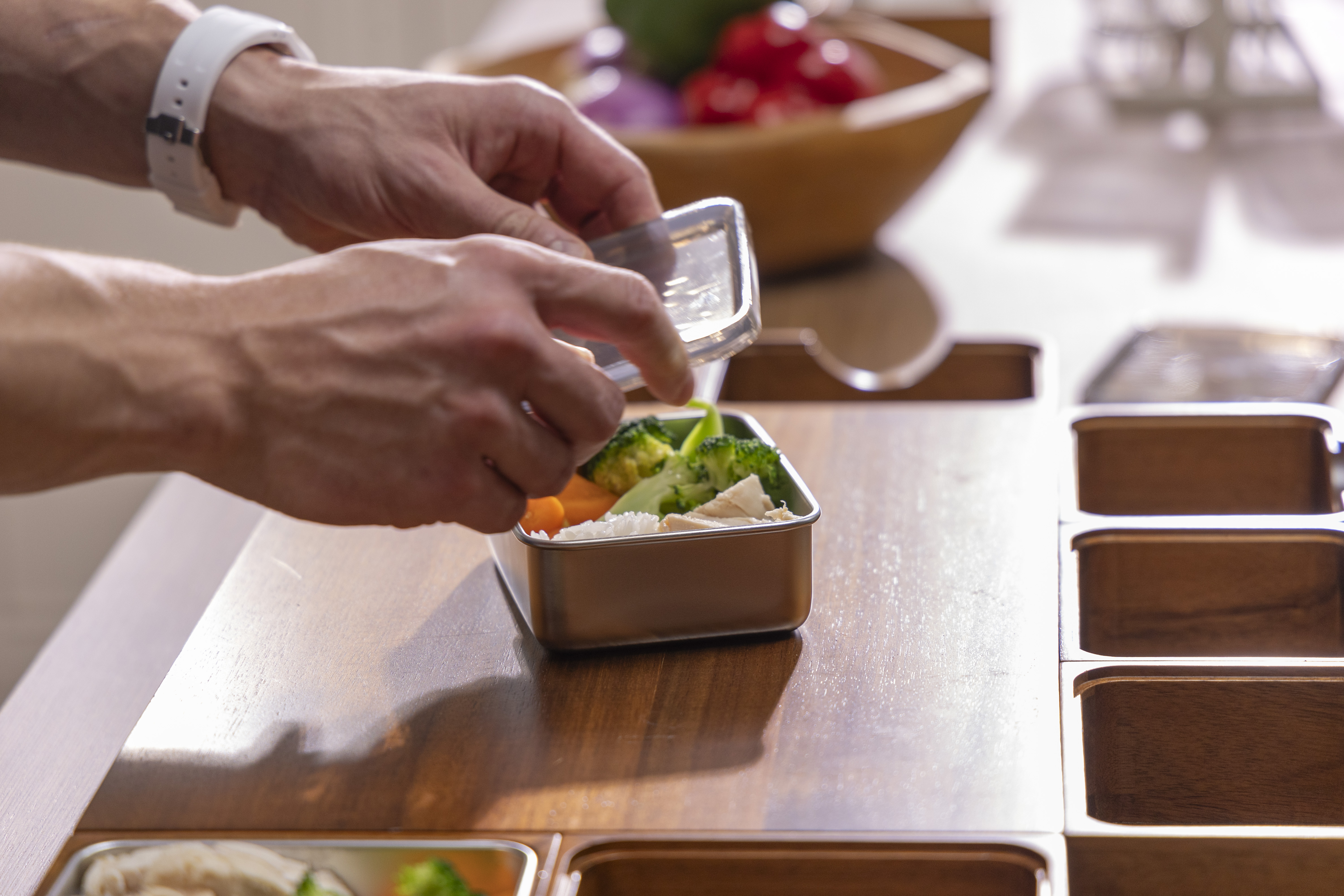 Prepared ingredients in stainless steel containers being moved from the PrepTop workstation